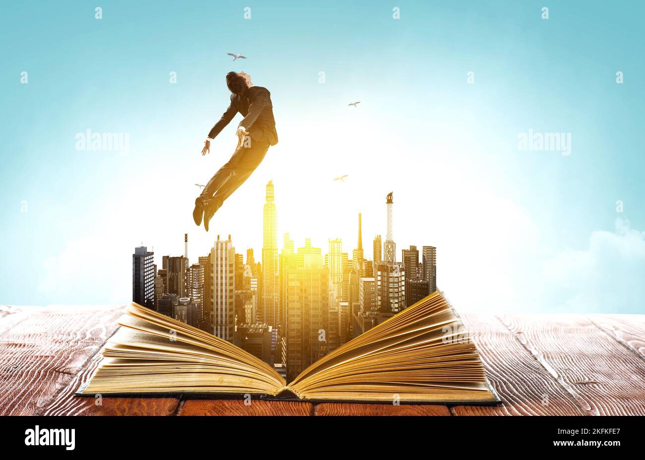Businessman in suit running on top of a book Stock Photo