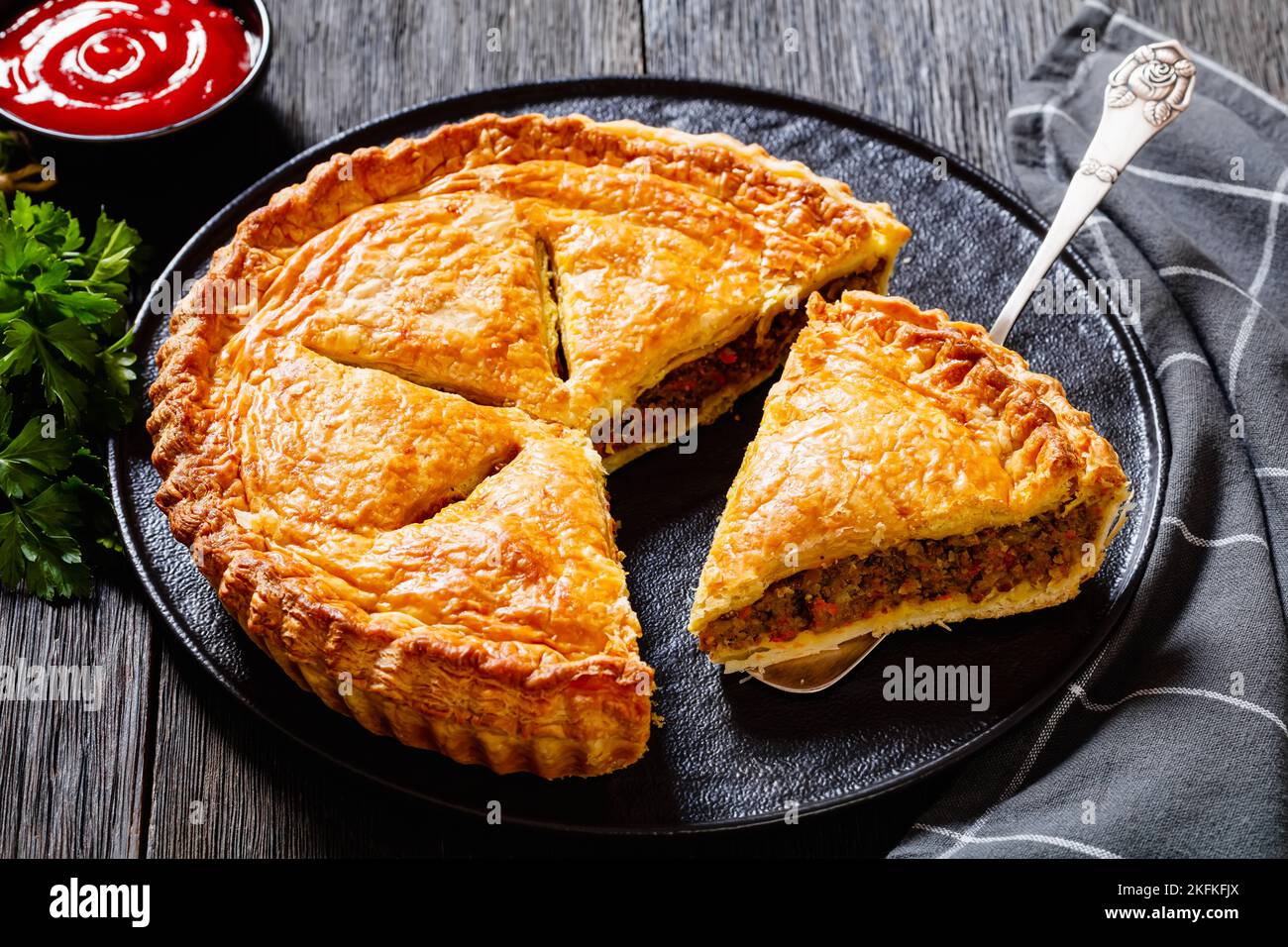 sliced Ground Beef Meat Pie with a flaky puff pastry double crust with ...