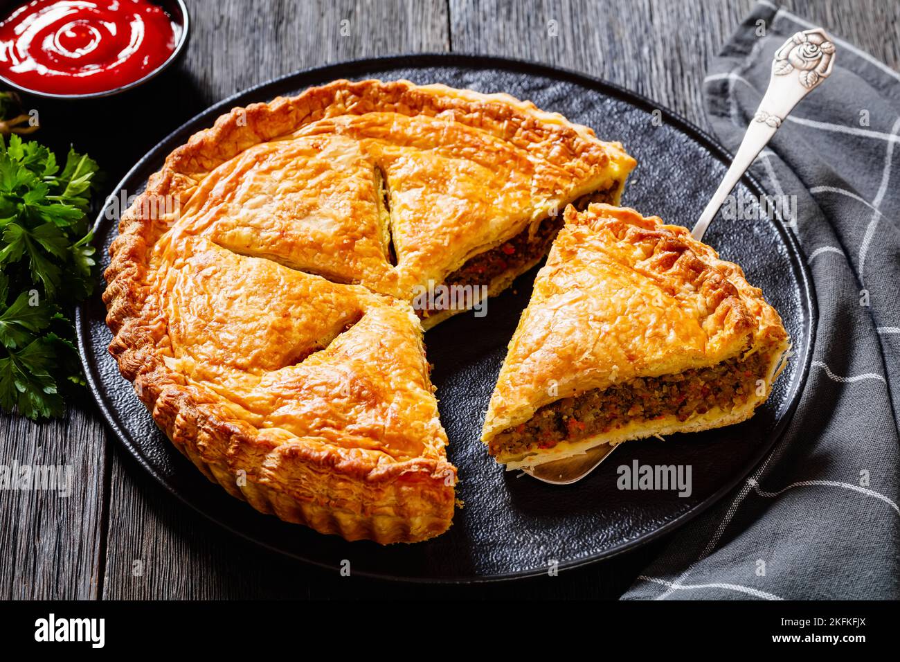 sliced Ground Beef Meat Pie with a flaky puff pastry double crust with