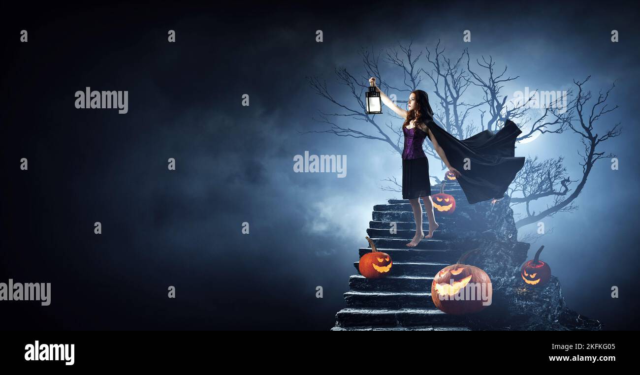Beautiful young woman in witches hat and costume Stock Photo