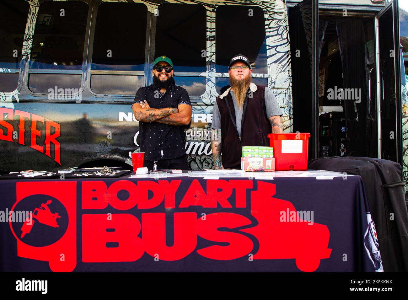 Alex Garcia (left), a tattoo artist, and Paul Newland, a piercer, host a mobile tattoo studio offering tattoos to Marines, Sailors and their families during the mixed martial arts Fight Night at Marine Corps Air Ground Combat Center (MCAGCC), Twentynine Palms, California, Sept. 23, 2022. Marine Corps Community Services hosted Fight Night for the service members stationed at MCAGCC to provide live entertainment closer to home. Stock Photo