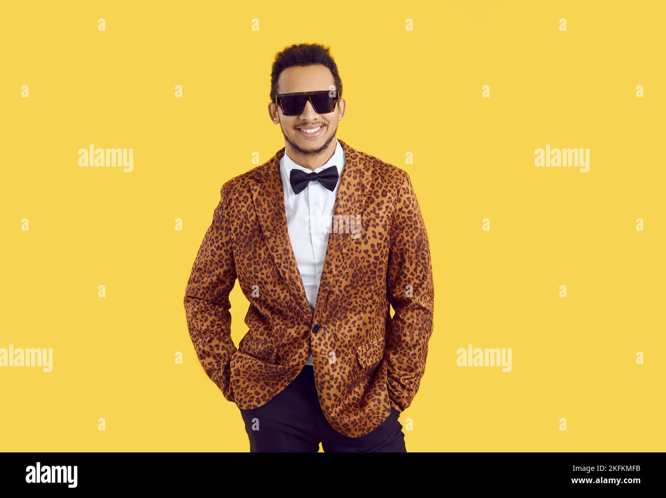 Studio shot of a confident young black man in a leopard jacket, bowtie and sunglasses Stock Photo