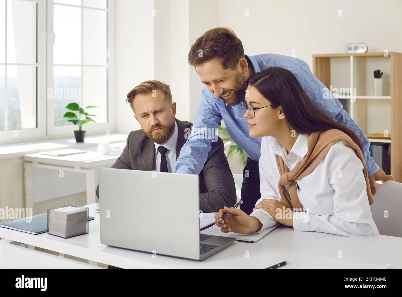 Team of confident business people analyzing data using laptop computer Stock Photo