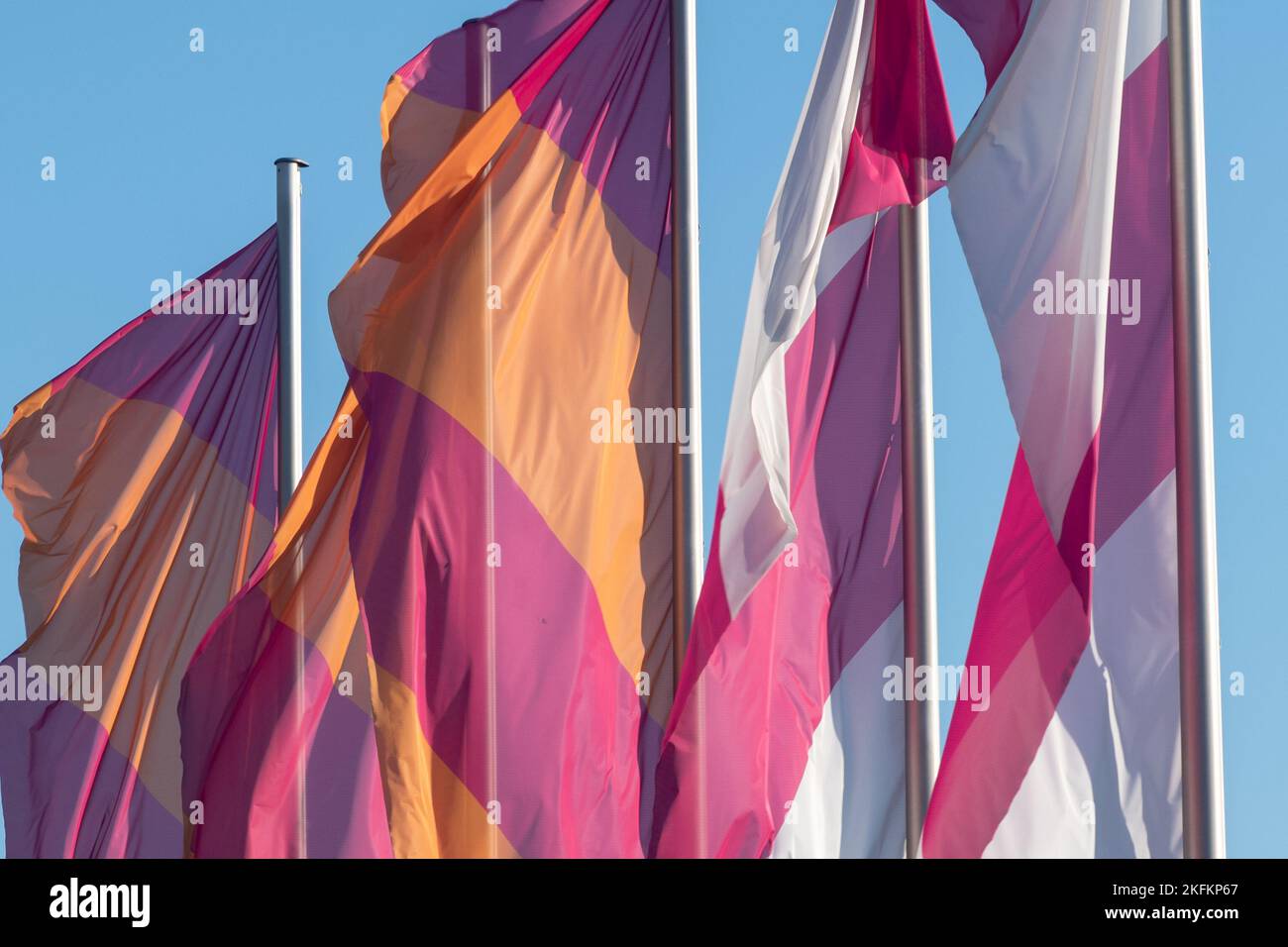 A closeup view of colorful flags on poles slightly blowing in the wind ...