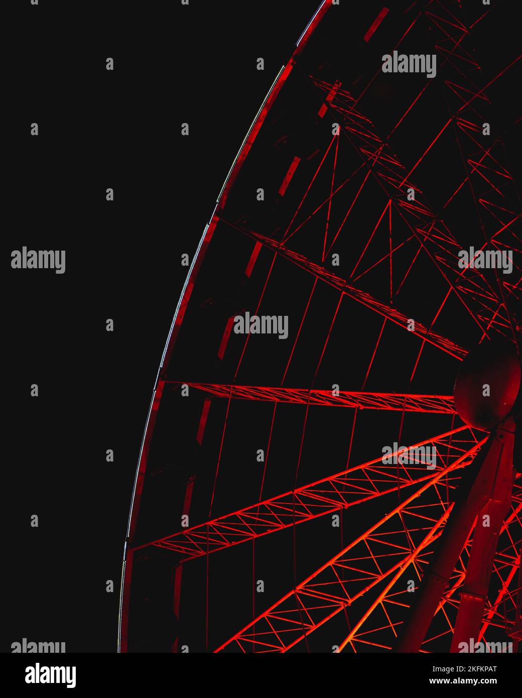 A low angle closeup shot of rotating Ferris wheel details with red ...