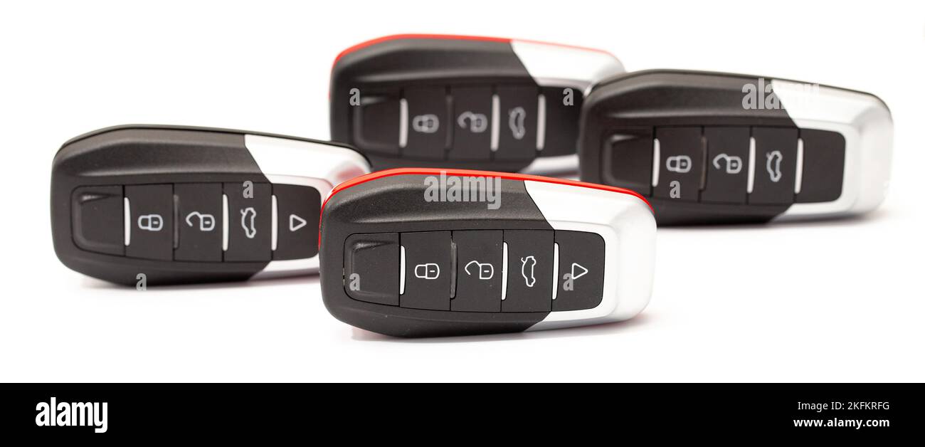 Car keys lie in different poses on a white background. Black and red car alarm key fobs are