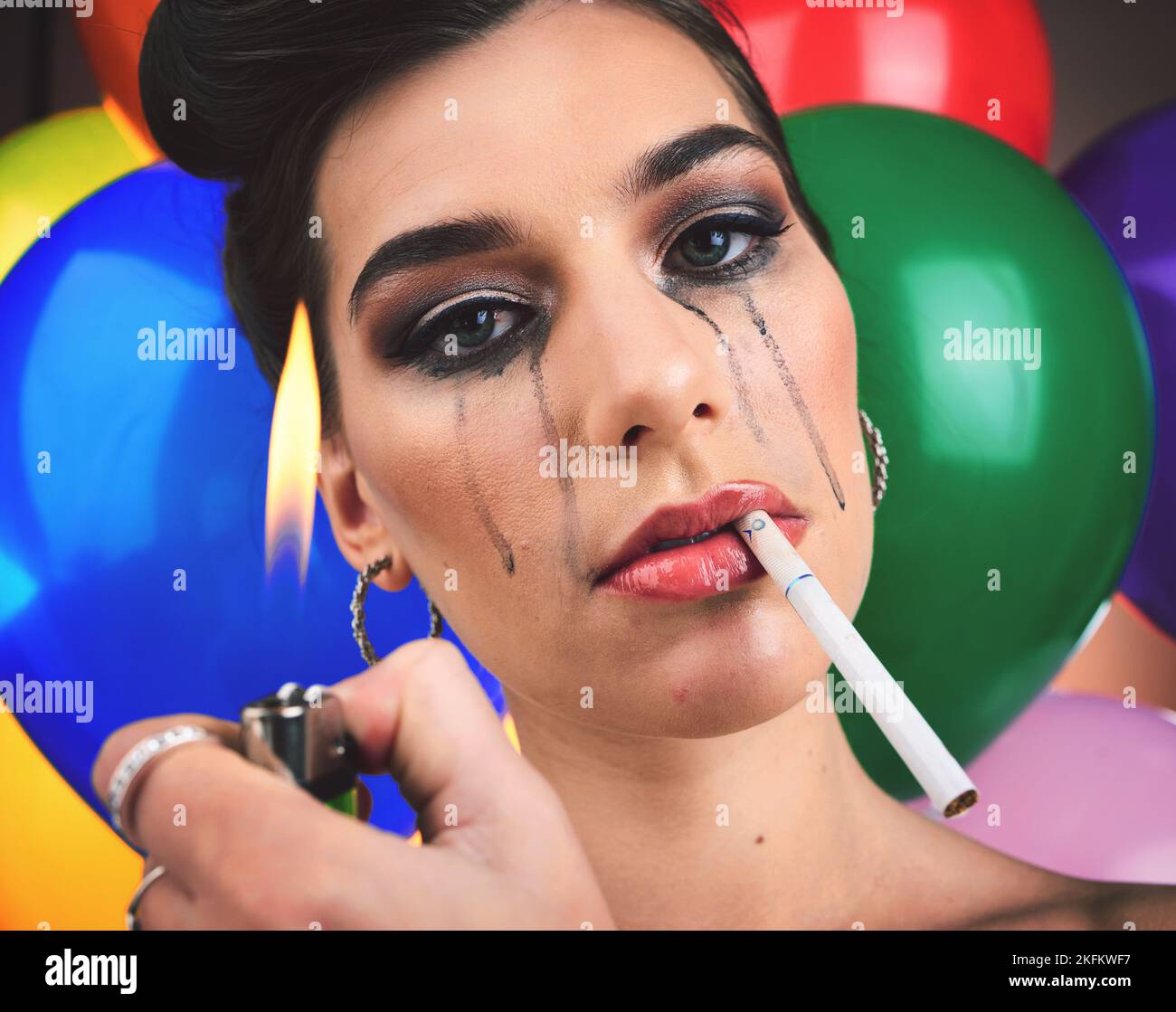 Crying woman, cigarette and balloons with psychology, mental health and depression problem with lighter flame for smoking. Face of a female feeling Stock Photo