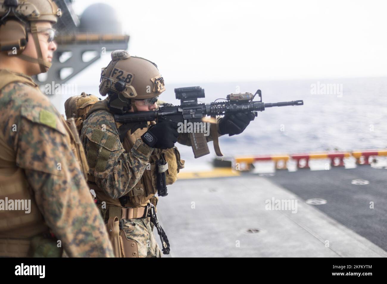 U.S. Marine with Maritime Raid Force, 31st Marine Expeditionary Unit conducts a firing drill while Sgt. Francisco Thompson, a squad leader with Battalion Landing Team 2/5, 31st Marine Expeditionary Unit refines his technique aboard Amphibious Assault Ship USS Tripoli (LHA-7), in the Philippine Sea, Sept. 24, 2022. The fast rope, shooting drill combo prepares Marines for inserting to a contested area. The 31st MEU is operating aboard ships of the Tripoli Amphibious Ready Group in the 7th Fleet area of operations to enhance interoperability with allies and partners and serve as a ready response Stock Photo