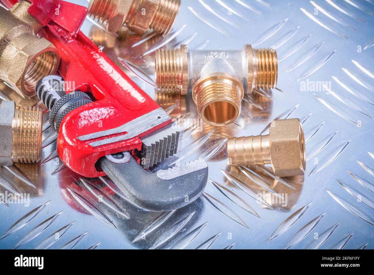 Collection of brass hardware on grooved metal background plumbing