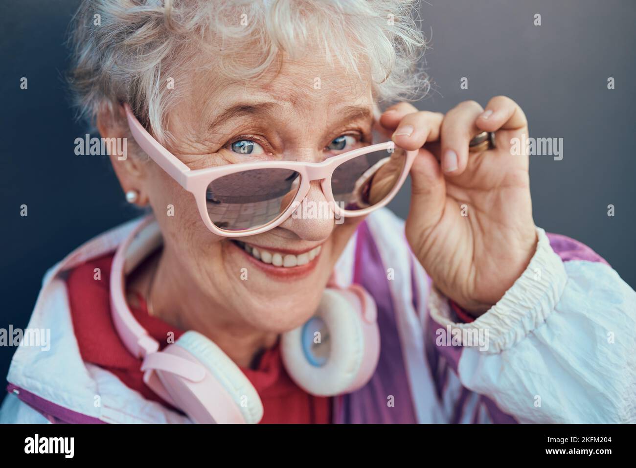 Face portrait and senior woman with sunglasses, headphones and vintage clothing. Fashion, beauty and happy, retired and elderly female in retro, cool Stock Photo