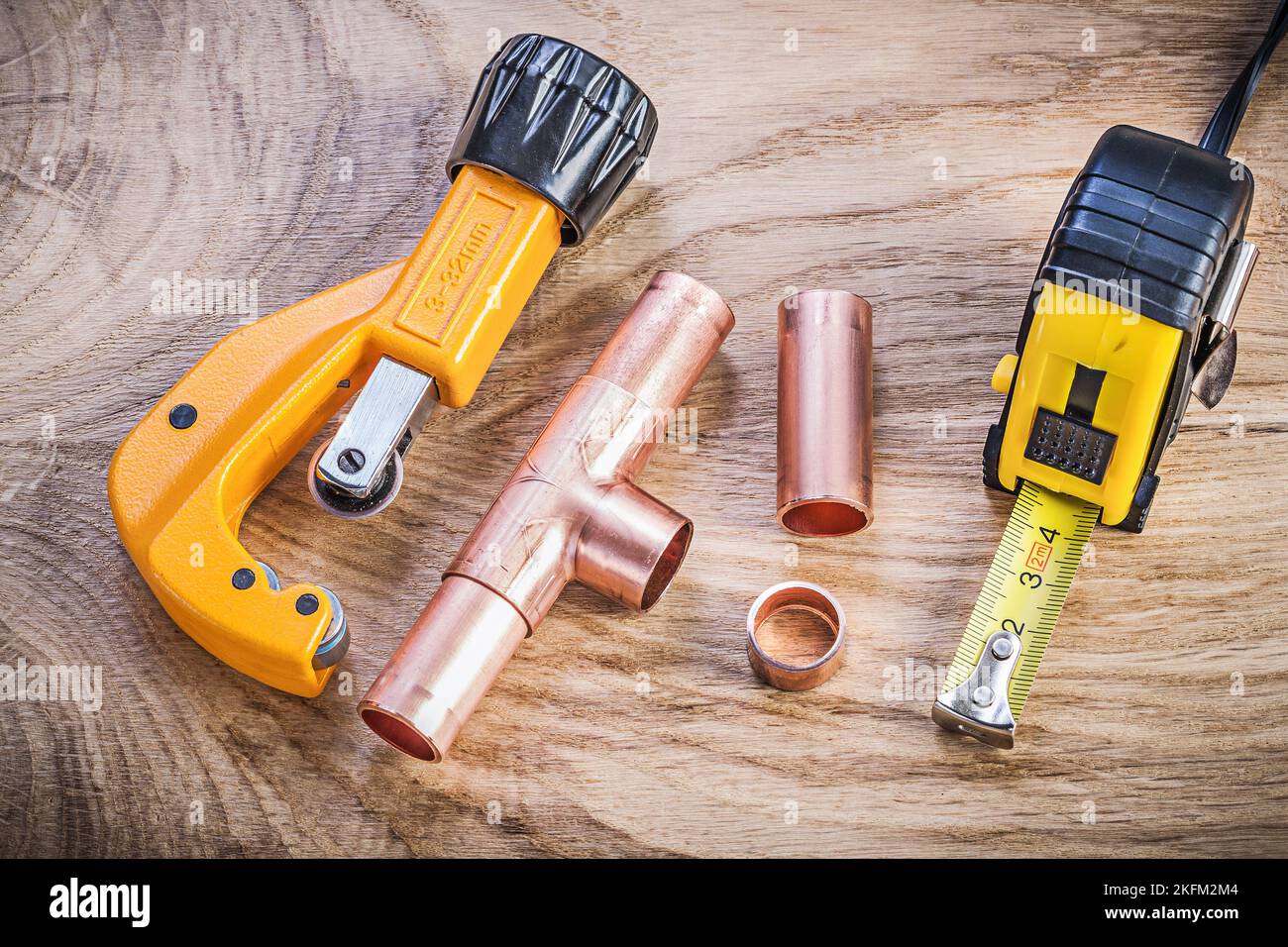 Copper water pipe cutter connectors tape measure on wood board plumbing