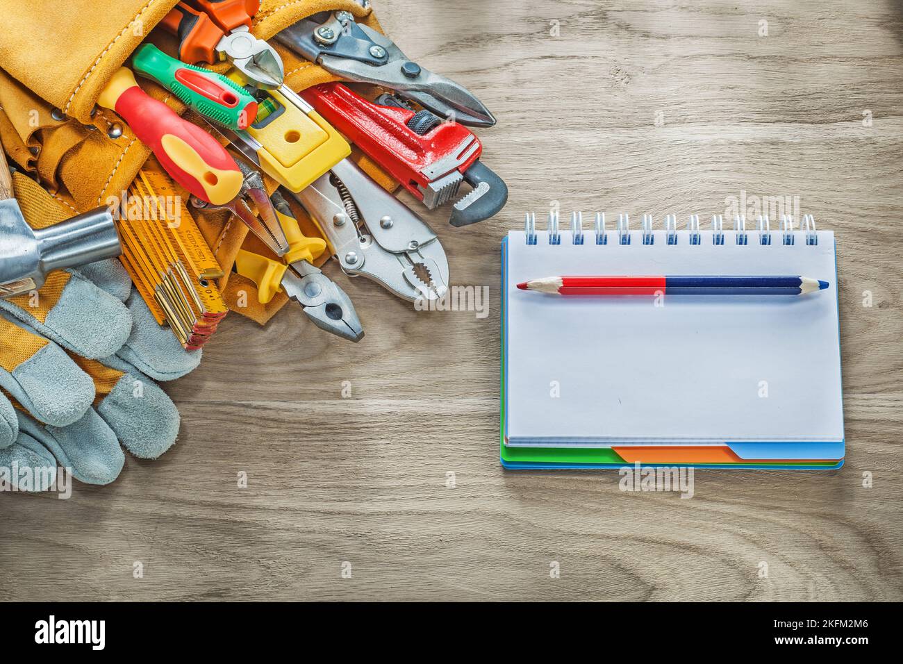 Construction tooling tool belt safety gloves claw hammer notebook pencil. Stock Photo