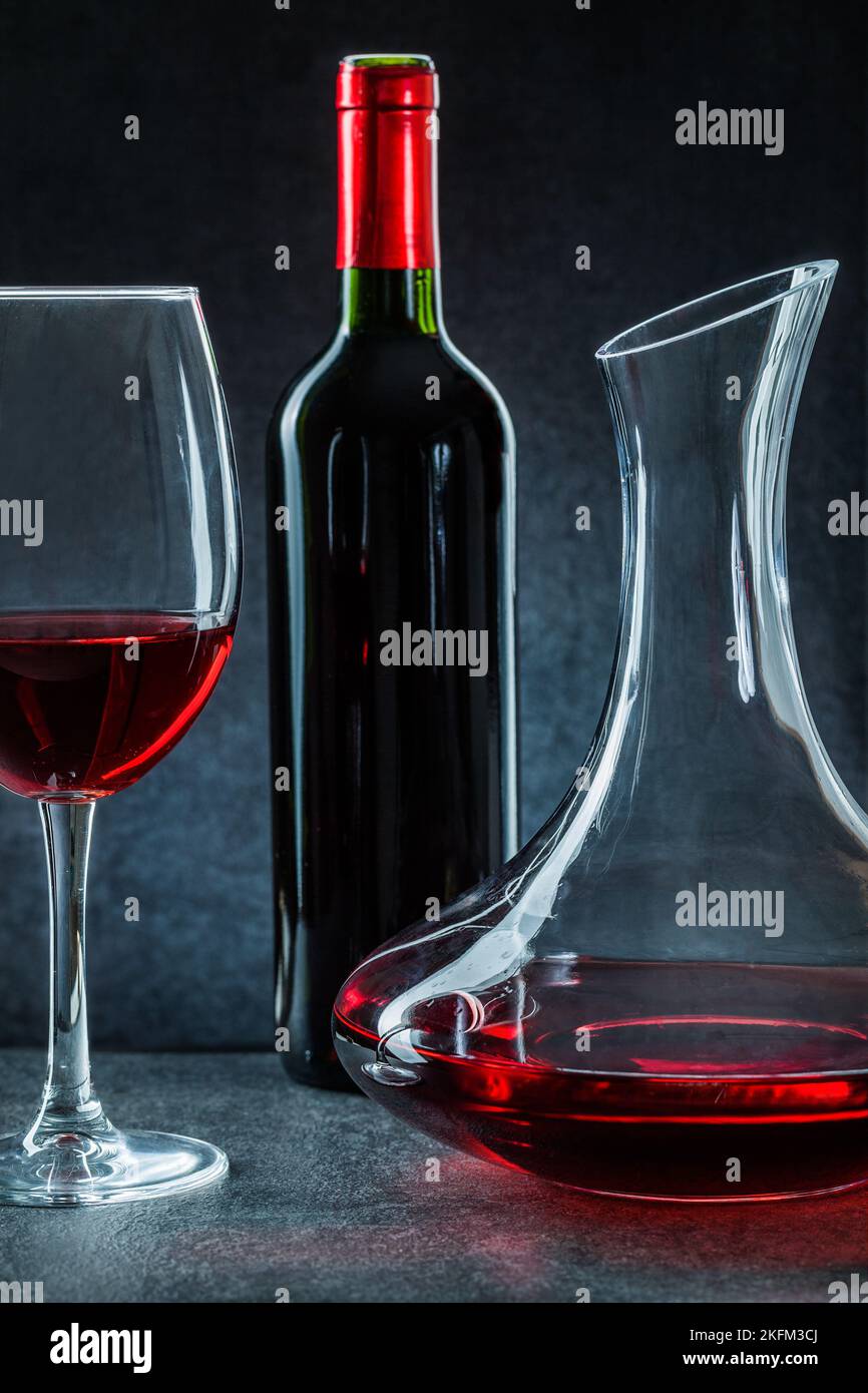 decanter wineglass and bottle with red wine on black background Stock Photo