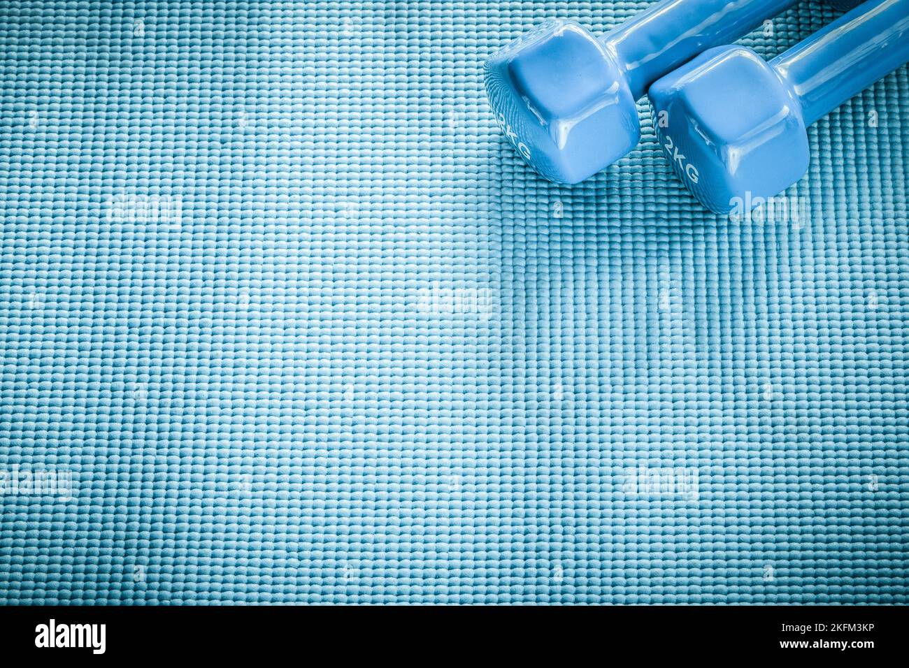 Dumb-bells on blue background fitness concept. Stock Photo