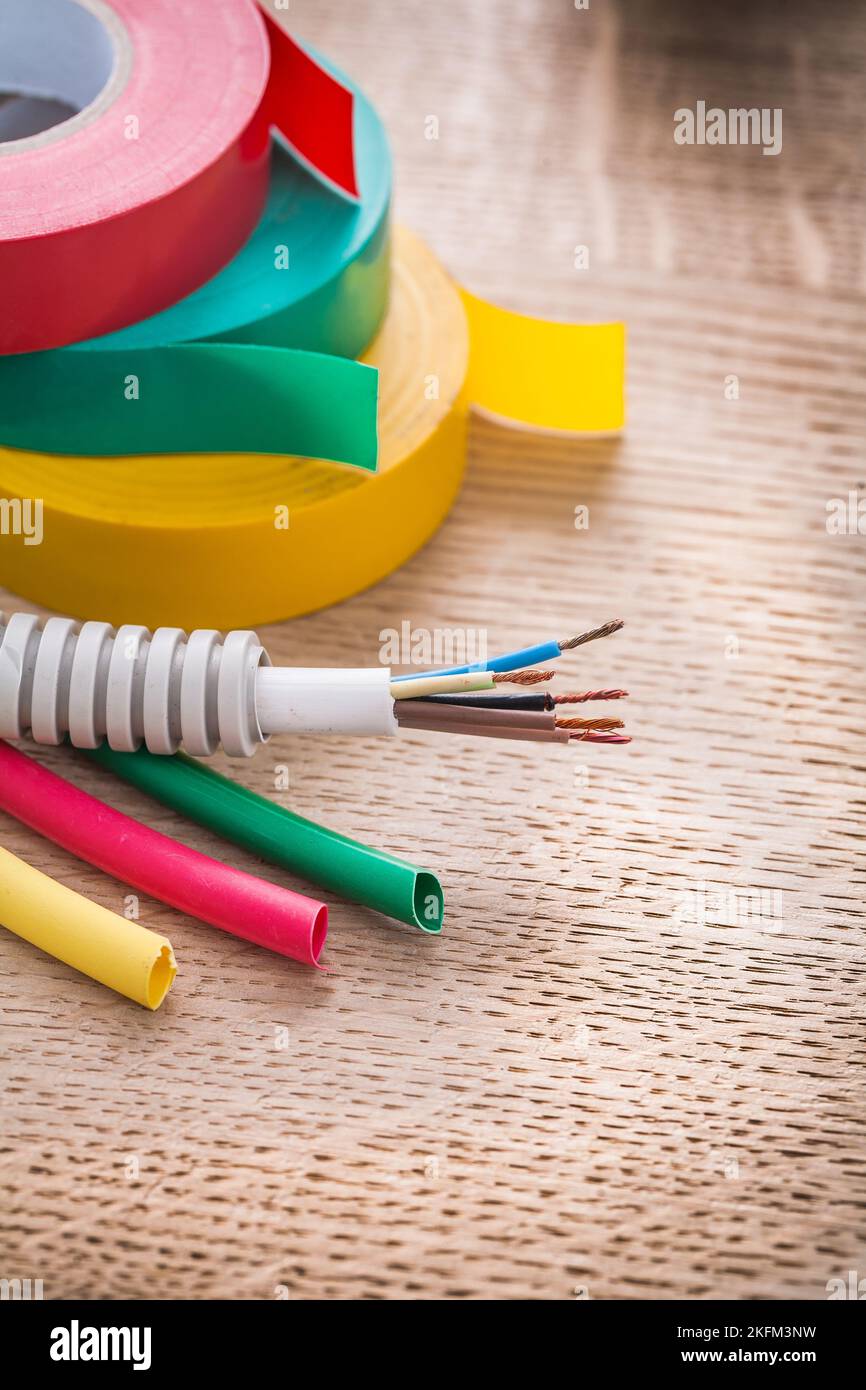 electric cable in corrugated pipe rolls of isulating tape heat shrinkable tubes on wooden board Stock Photo