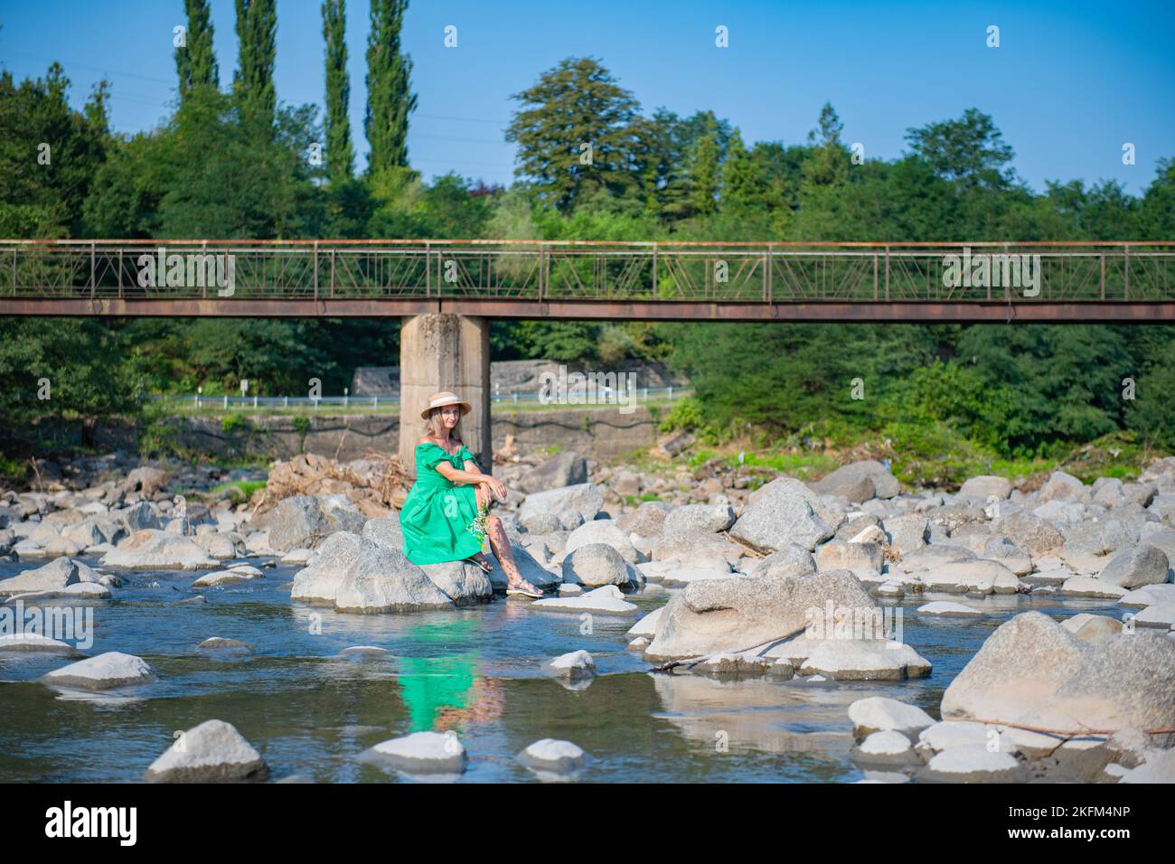 a girl in a hat is sitting on a stone Stock Photo - Alamy