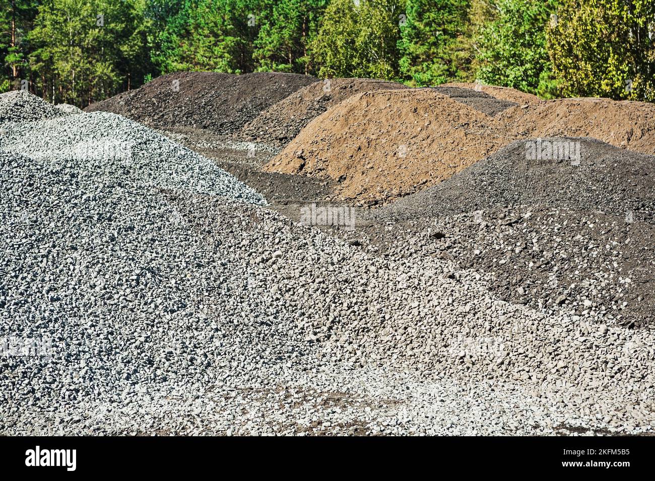 piles of gravel and mixed sand on construction site in forest Stock