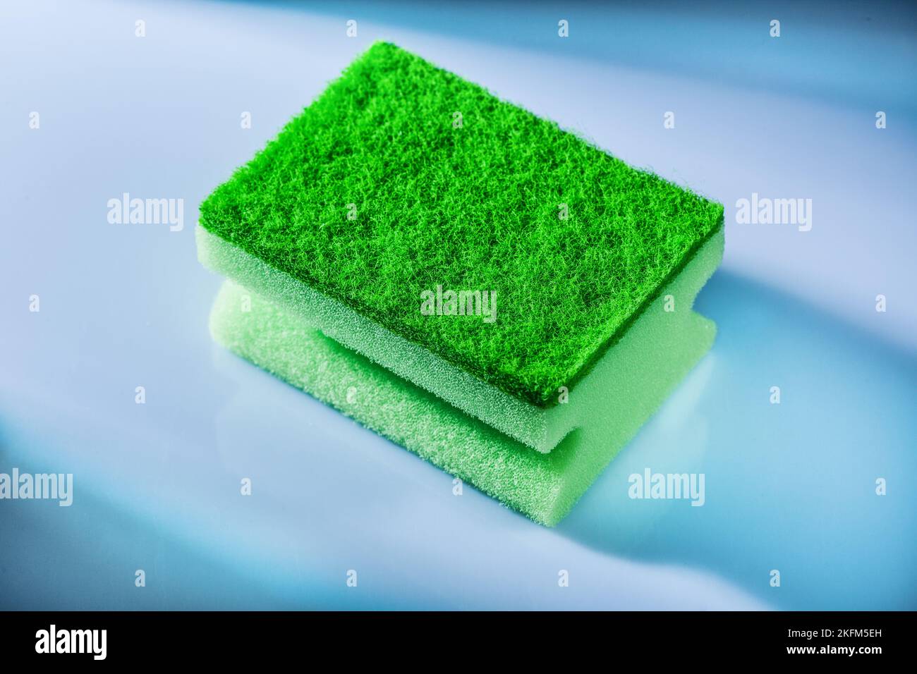 Green sponge on white background. Stock Photo