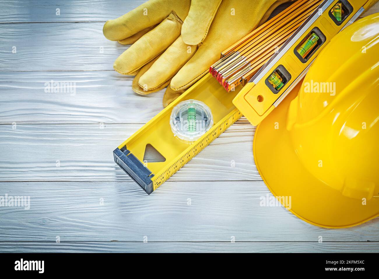 Hard hat protective gloves construction level on white board. Stock Photo