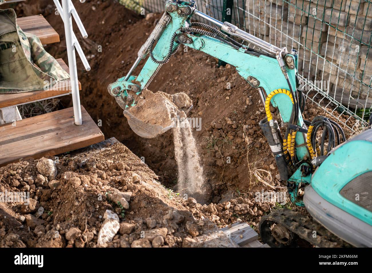 Mini excavator digs a trench to lay pipes. Close up of an excavator