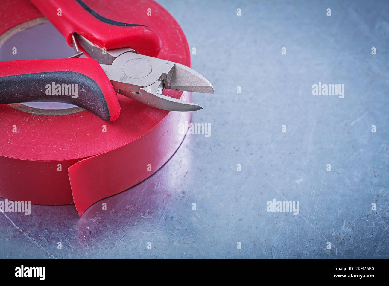 Insulation tape cutting pliers on metallic background construction