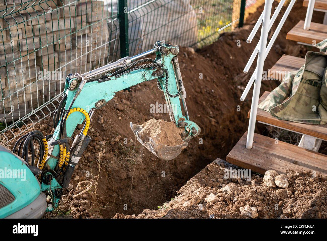 Mini excavator digs a trench to lay pipes. Close up of an excavator
