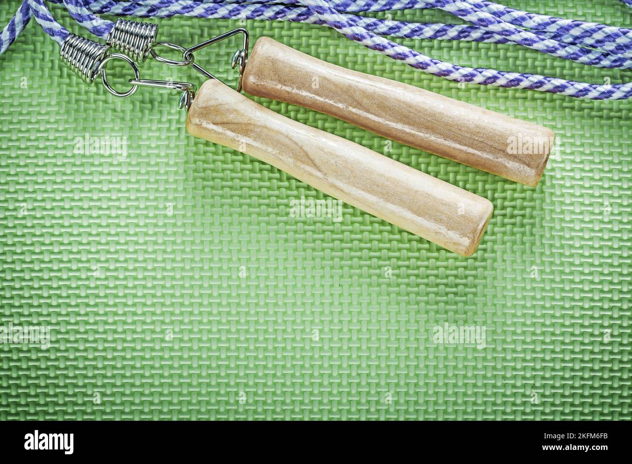 Jumping rope with wooden handles on green surface sports training ...