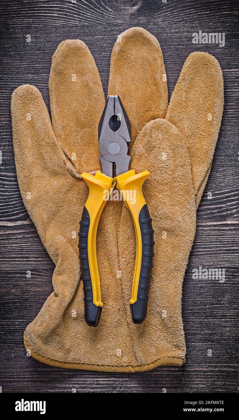 Leather safety glove tin snips on wooden board vertical version Stock