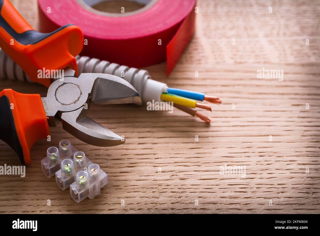 nippers insulating tape and terminal blocks for electric cables  on wooden board Stock Photo
