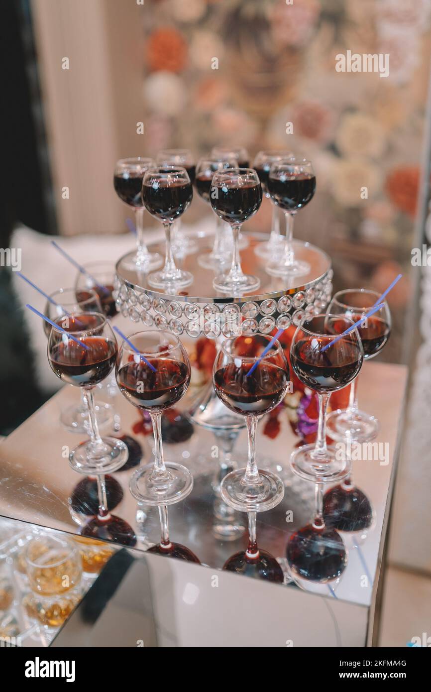 Pyramid of glasses with Martini cocktail for a festive reception at the wedding on the table. Cosmopolitan cherry cocktail Isolated. Stock Photo