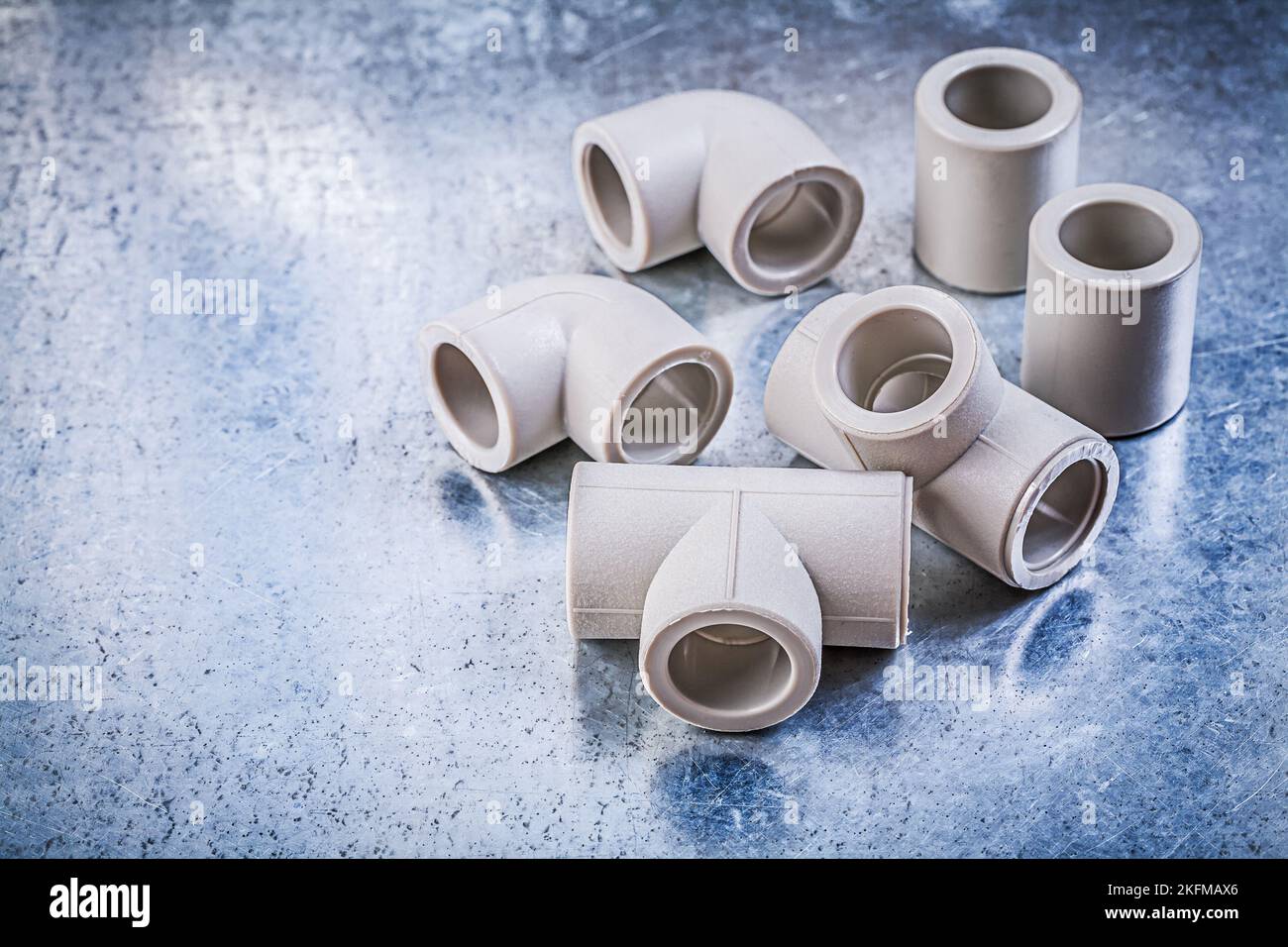 Plastic pipe fittings on metallic surface construction concept Stock
