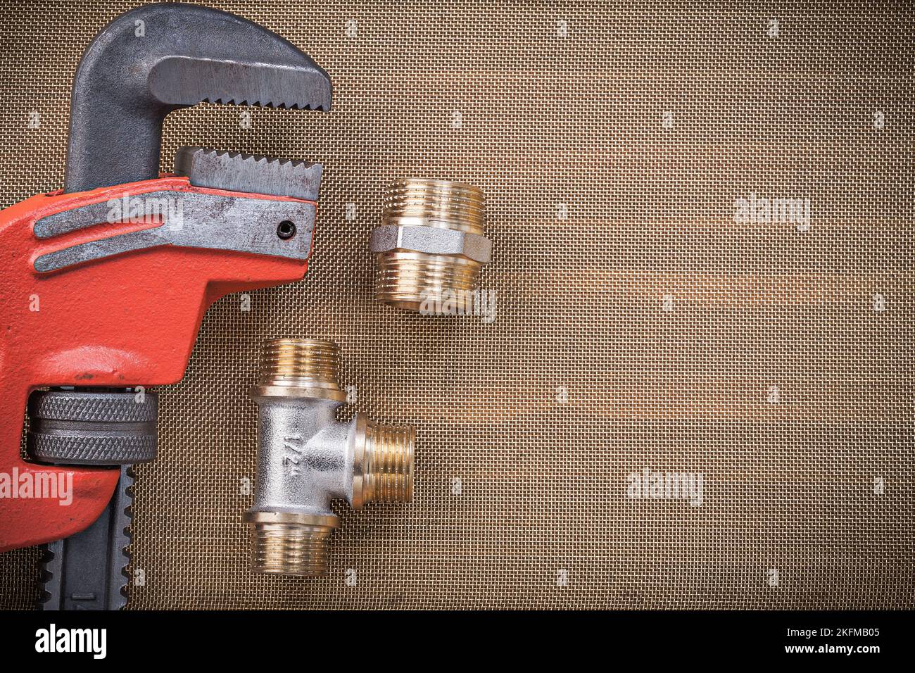Plumbers wrench brass connector fittings on cleaning mesh filter grid