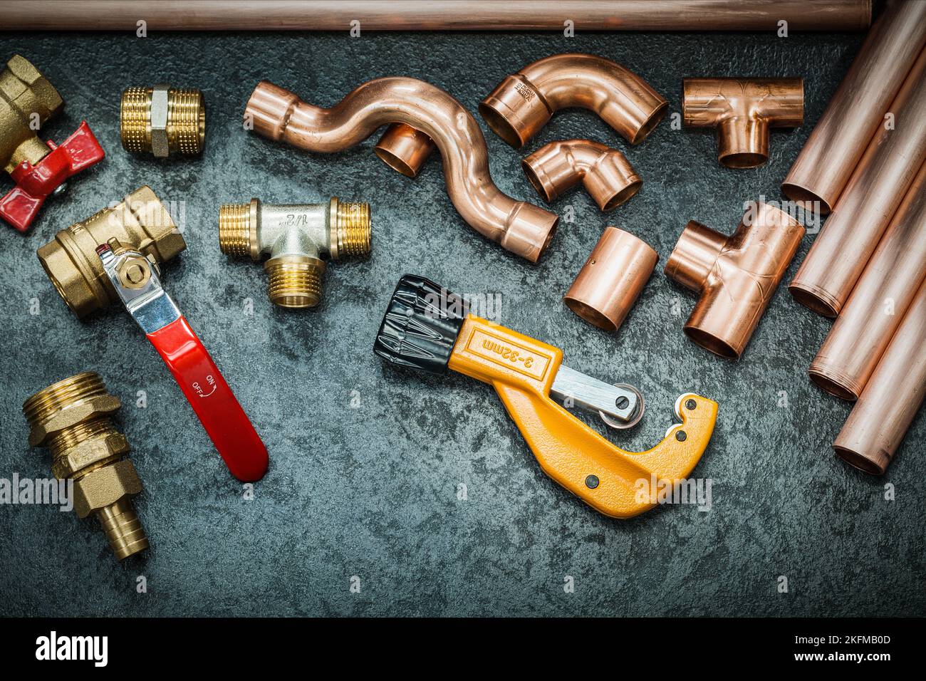 plumbers tools copper pipes fittings pipe cutter and valwes on black background Stock Photo