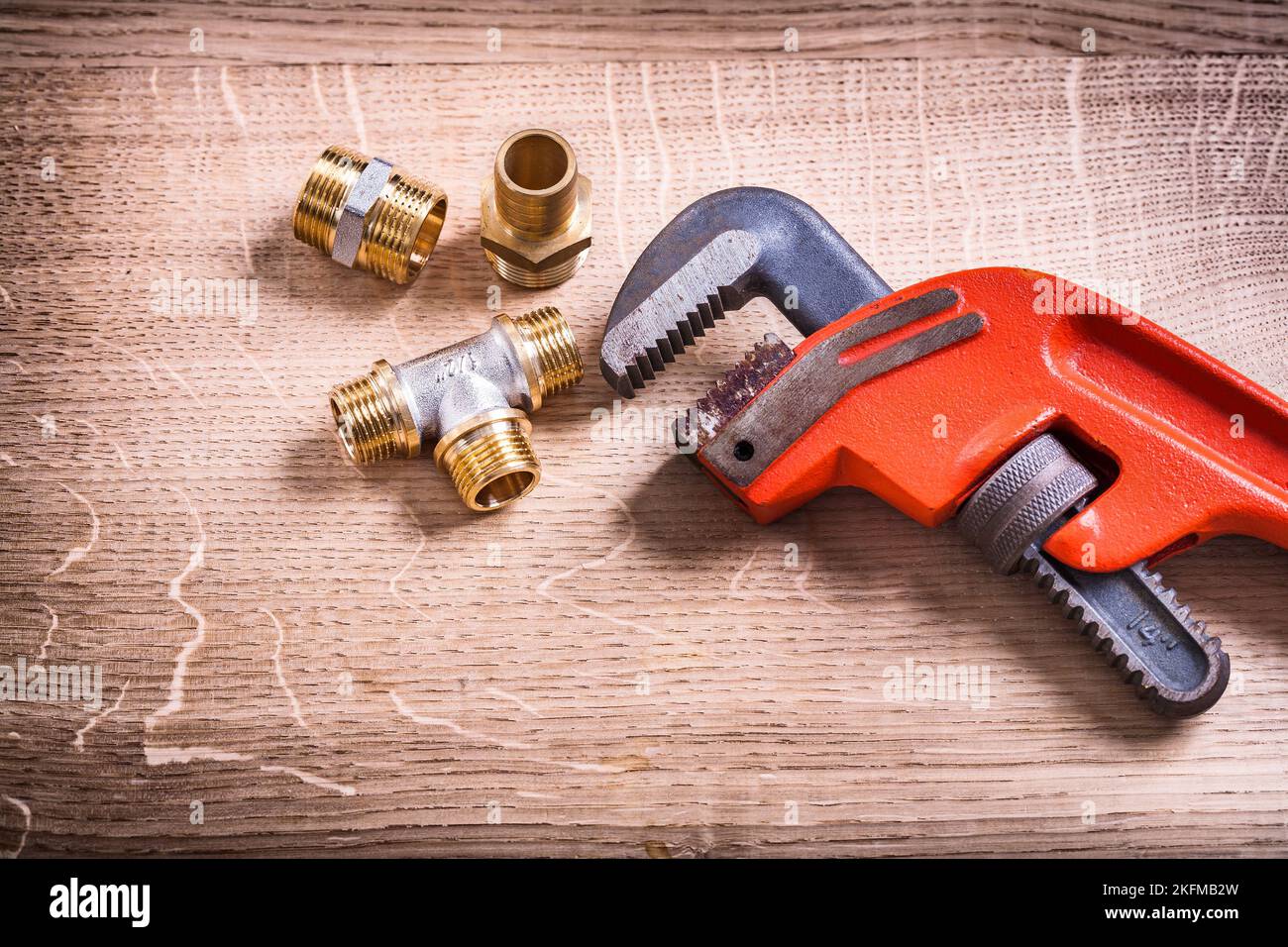 Plumbing tools composition of brass pipe connectors on wooden board and
