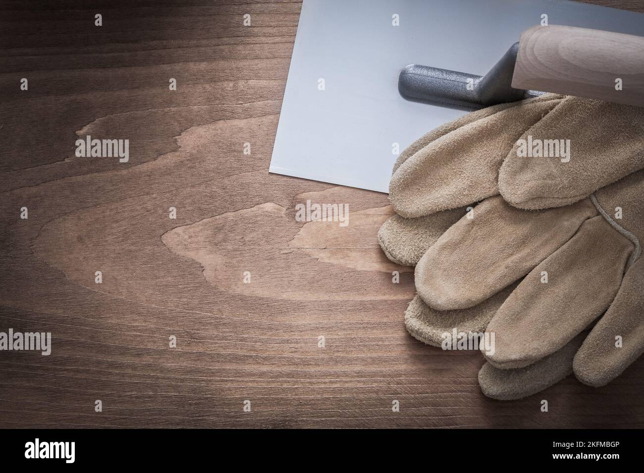 Protective gloves and plastering trowel construction concept. Stock Photo