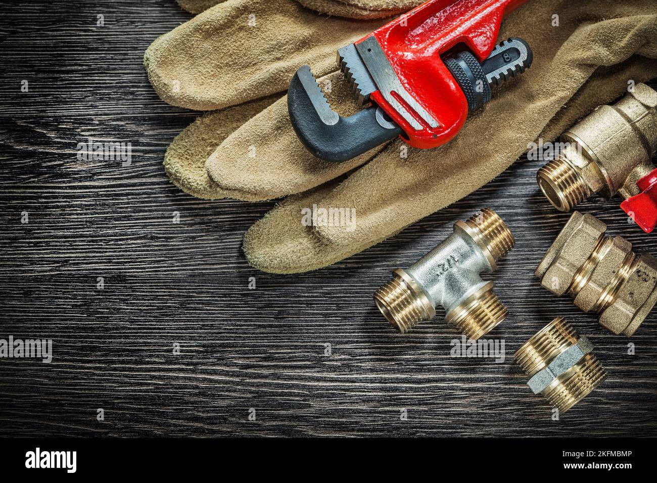 Protective gloves plumbing pipe wrench connectors water valve on wooden ...
