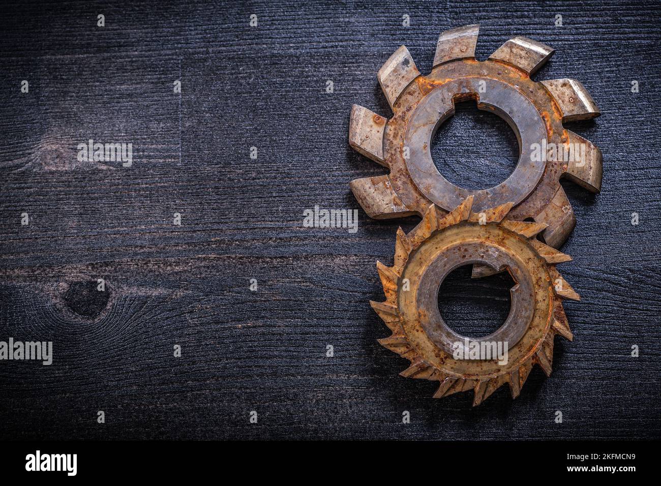 Rusty obsolete rotary cutters on wooden surface construction concept ...