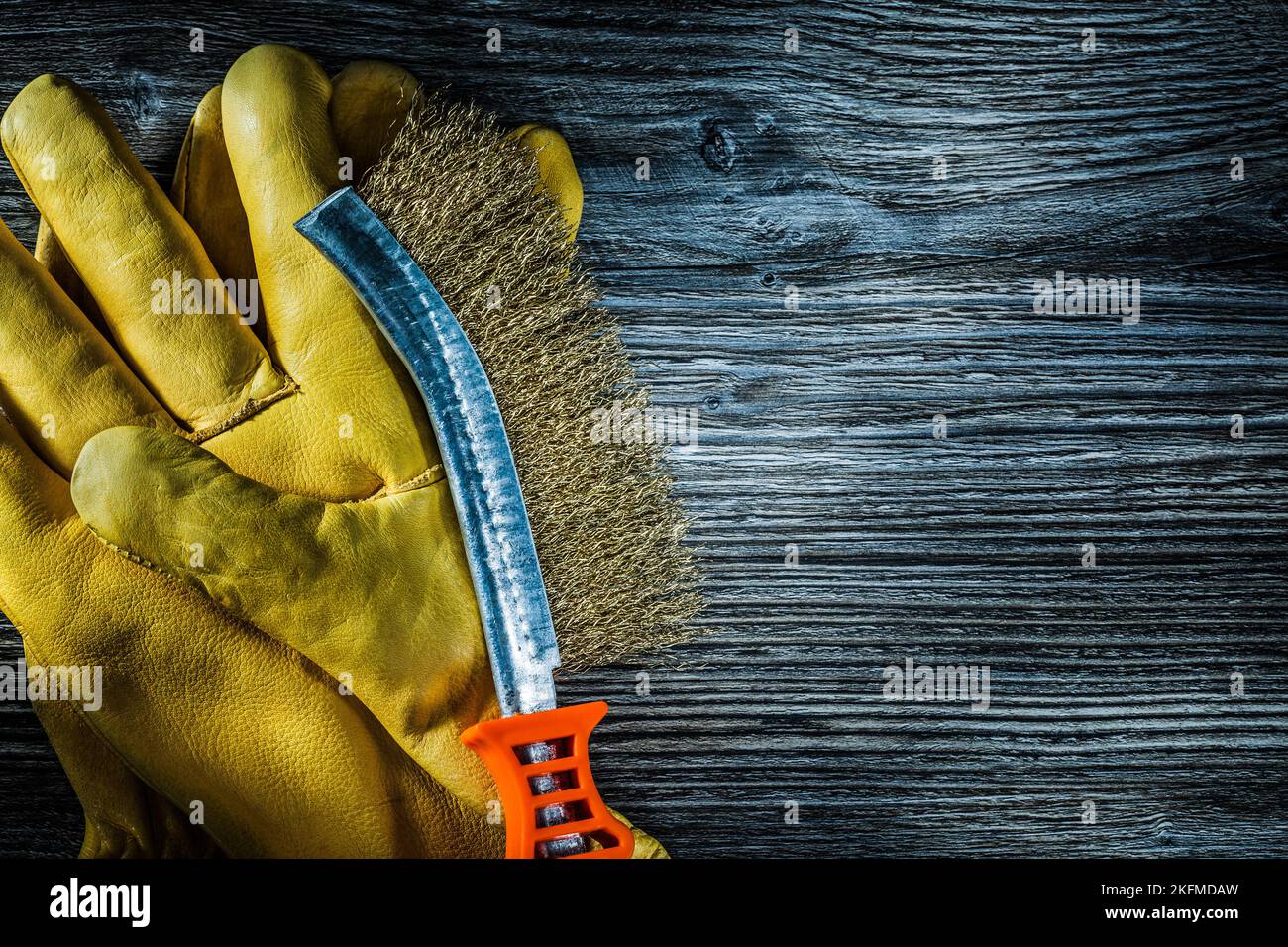 Scratch wire brush leather protective gloves on vintage wooden board. Stock Photo