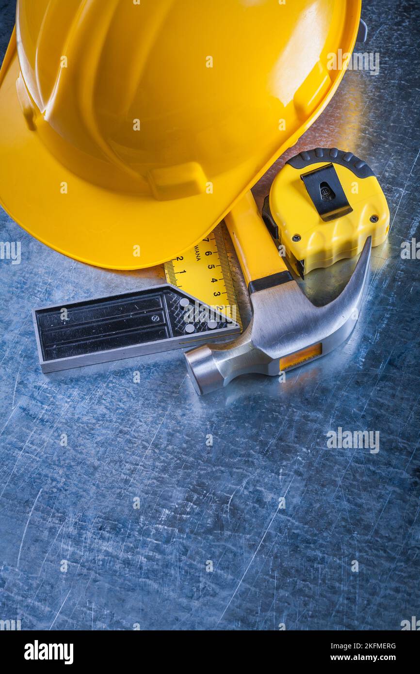 Square ruler measuring tape protective hard hat and claw hammer on ...