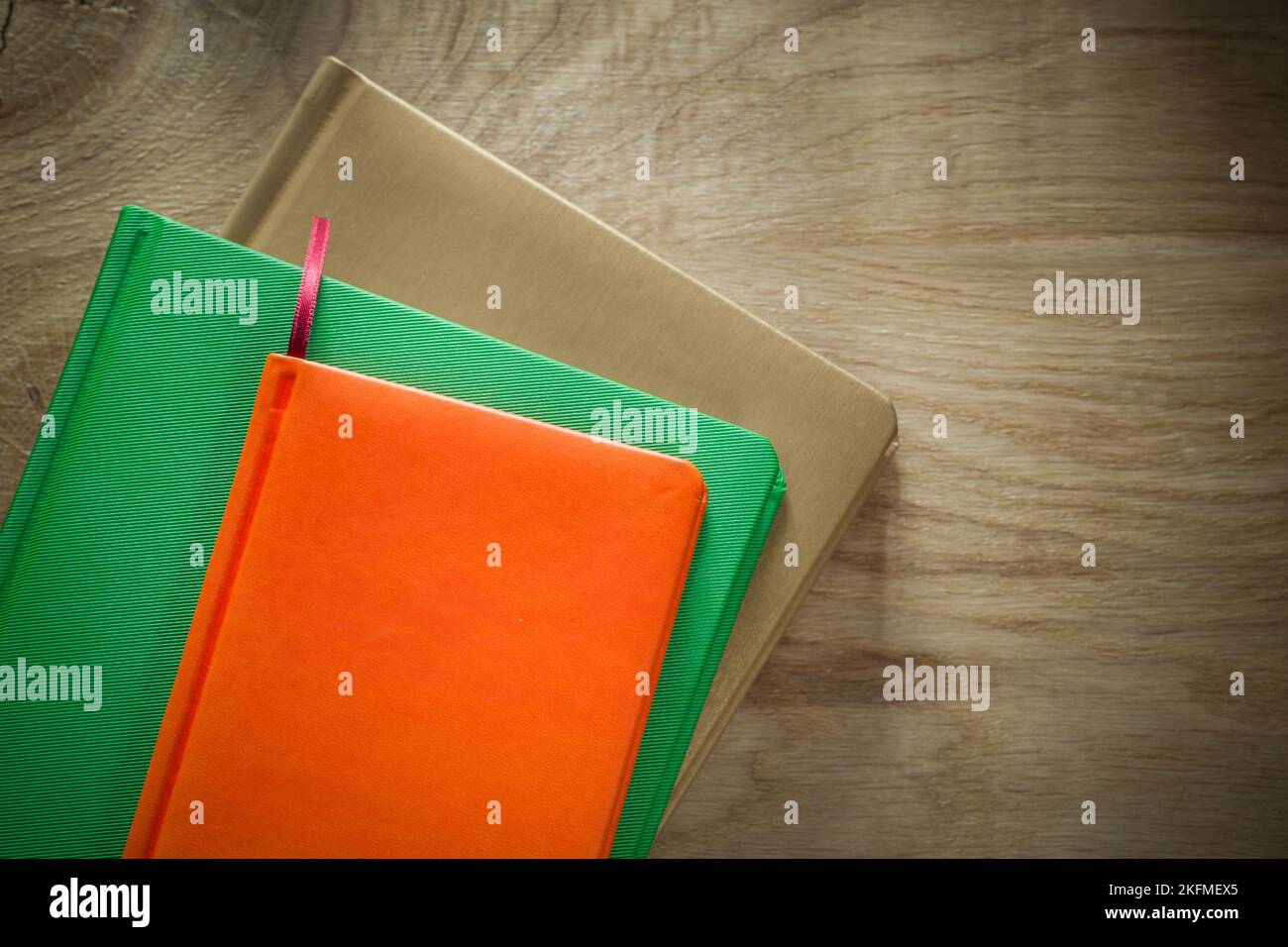 Stack of notebooks on wooden board. Stock Photo