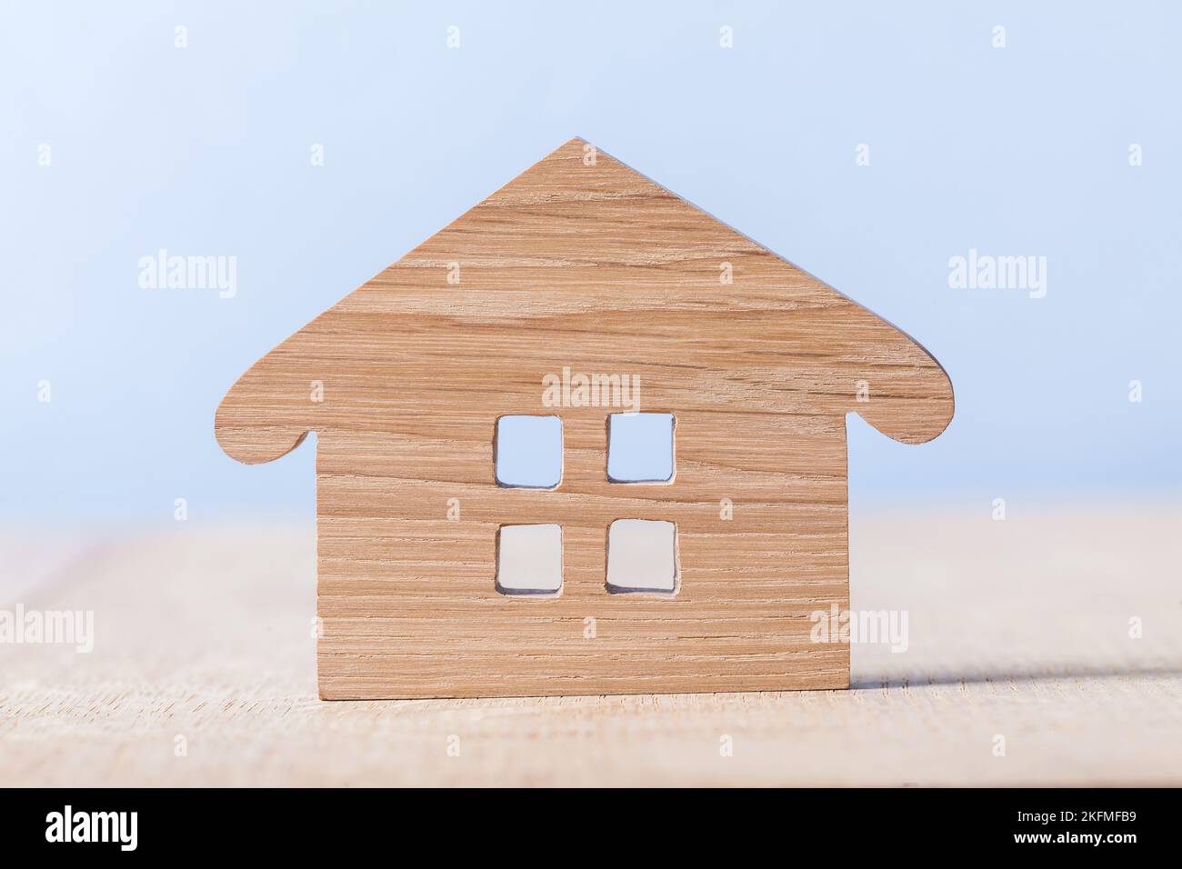 symbol of wooden house on blue and wooden background Stock Photo