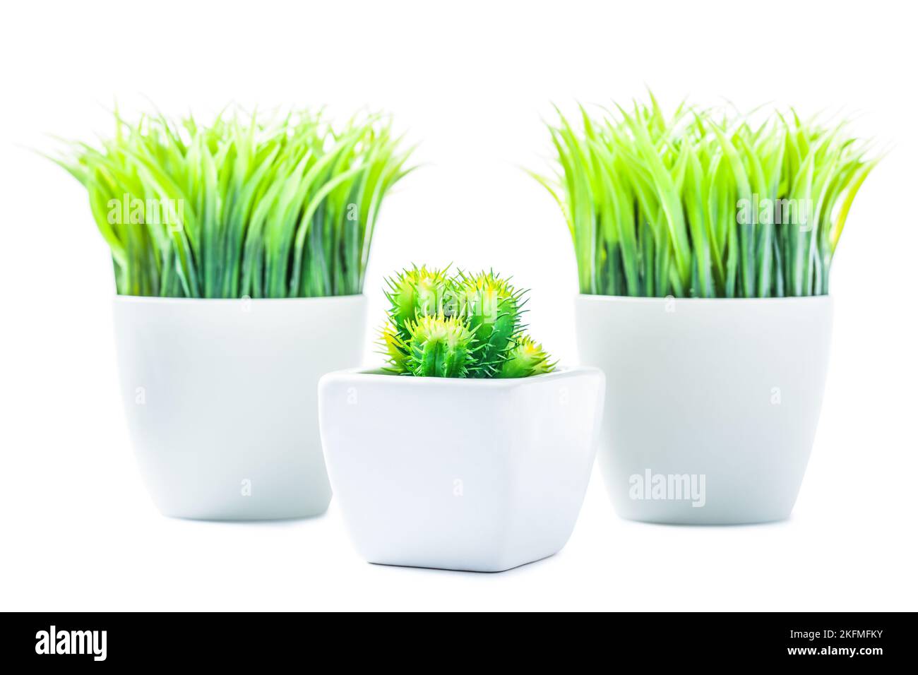 three pots with artificial plants plastic plants isolated Stock Photo