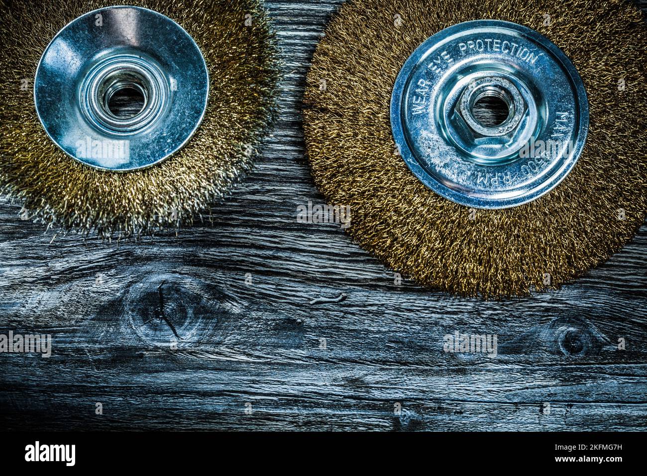 Used brass wheel brushes on vintage wooden board. Stock Photo