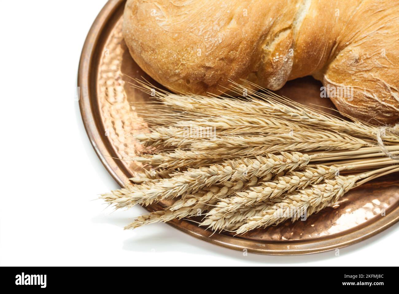 wheat ears loaf of bread on vintage brass tray isolated white Stock Photo