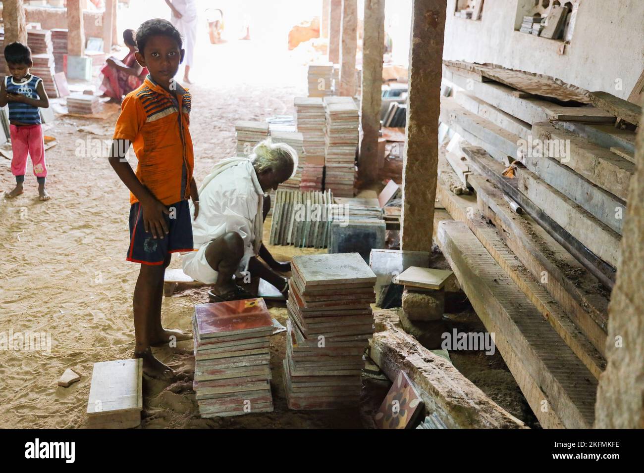 Young boy stacking Athangudi tiles in Attangudi,Tamil Nadu,India . Stock Photo