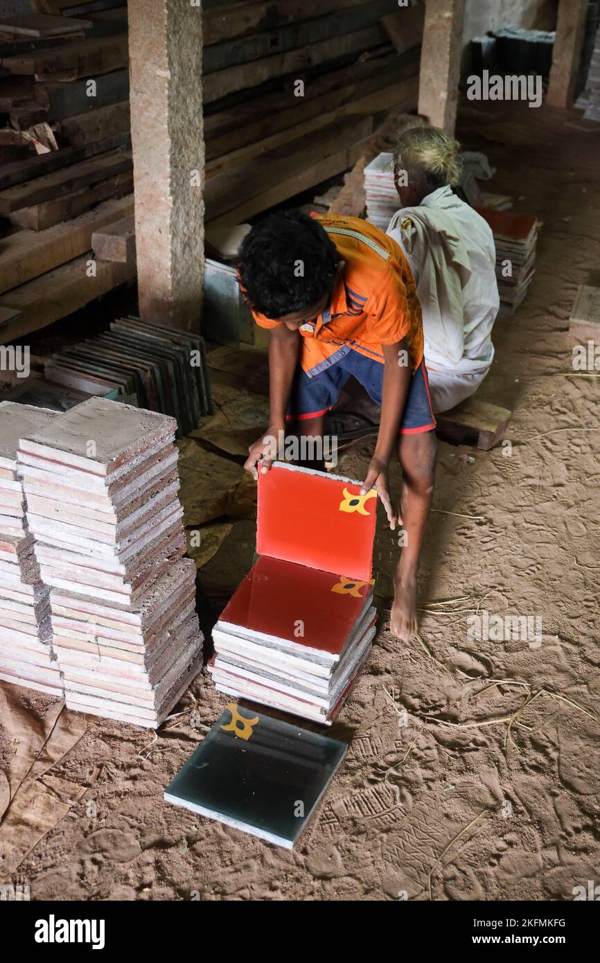 Young boy stacking Athangudi tiles in Attangudi,Tamil Nadu,India . Stock Photo