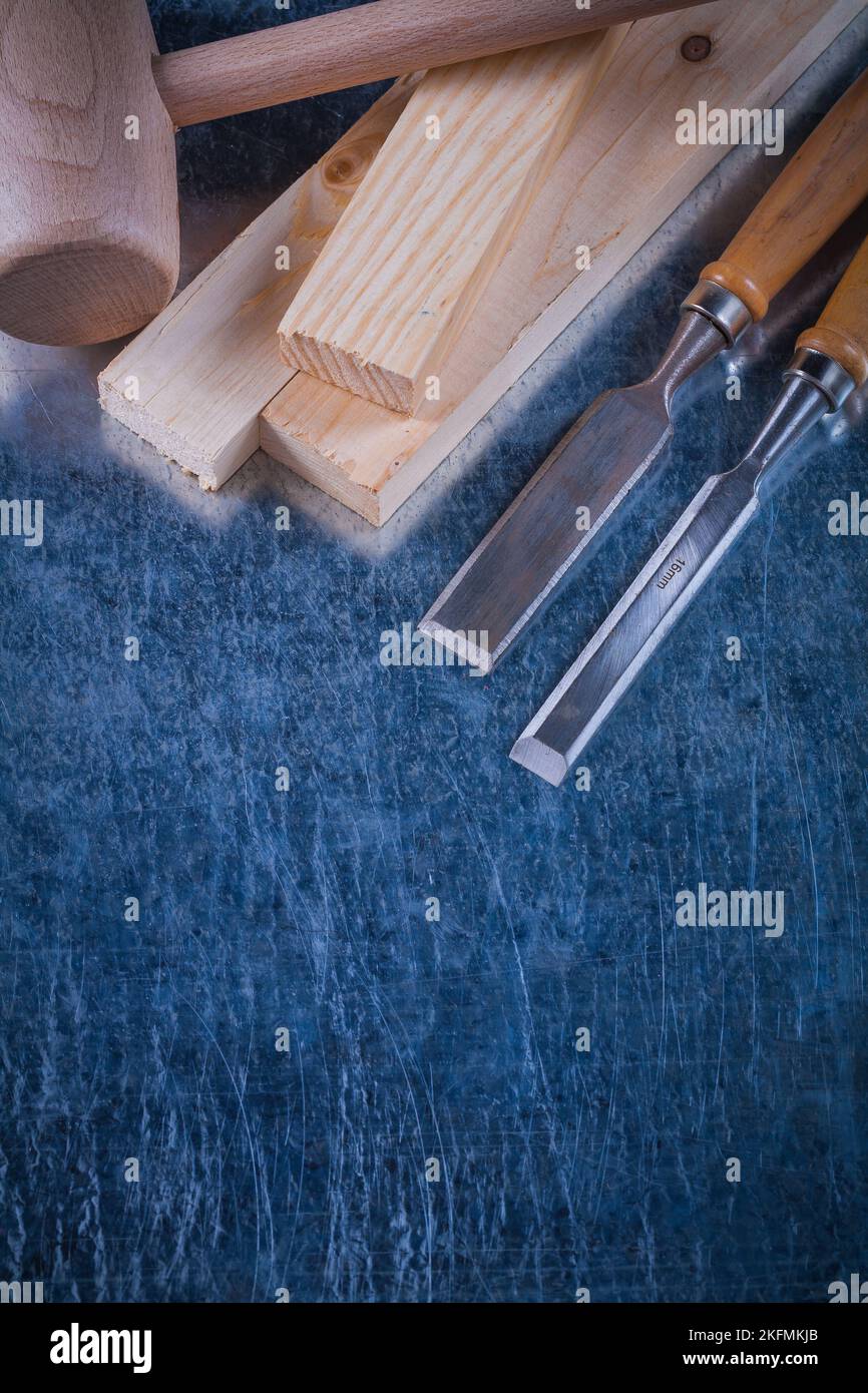 Wooden mallet bricks and flat chisels on scratched metallic surface ...
