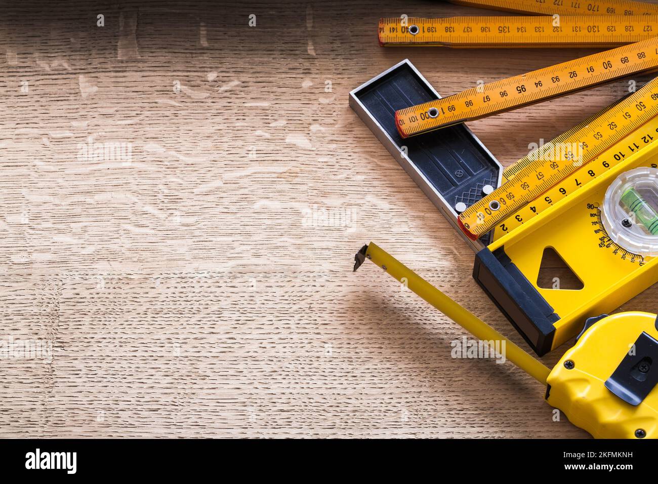 Wooden meter tape measure construction level and square ruler on oaken