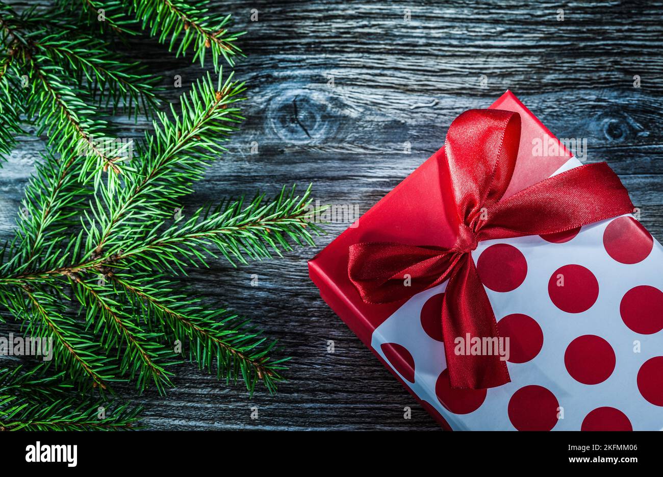 Wrapped gift box fir branches on wooden board. Stock Photo