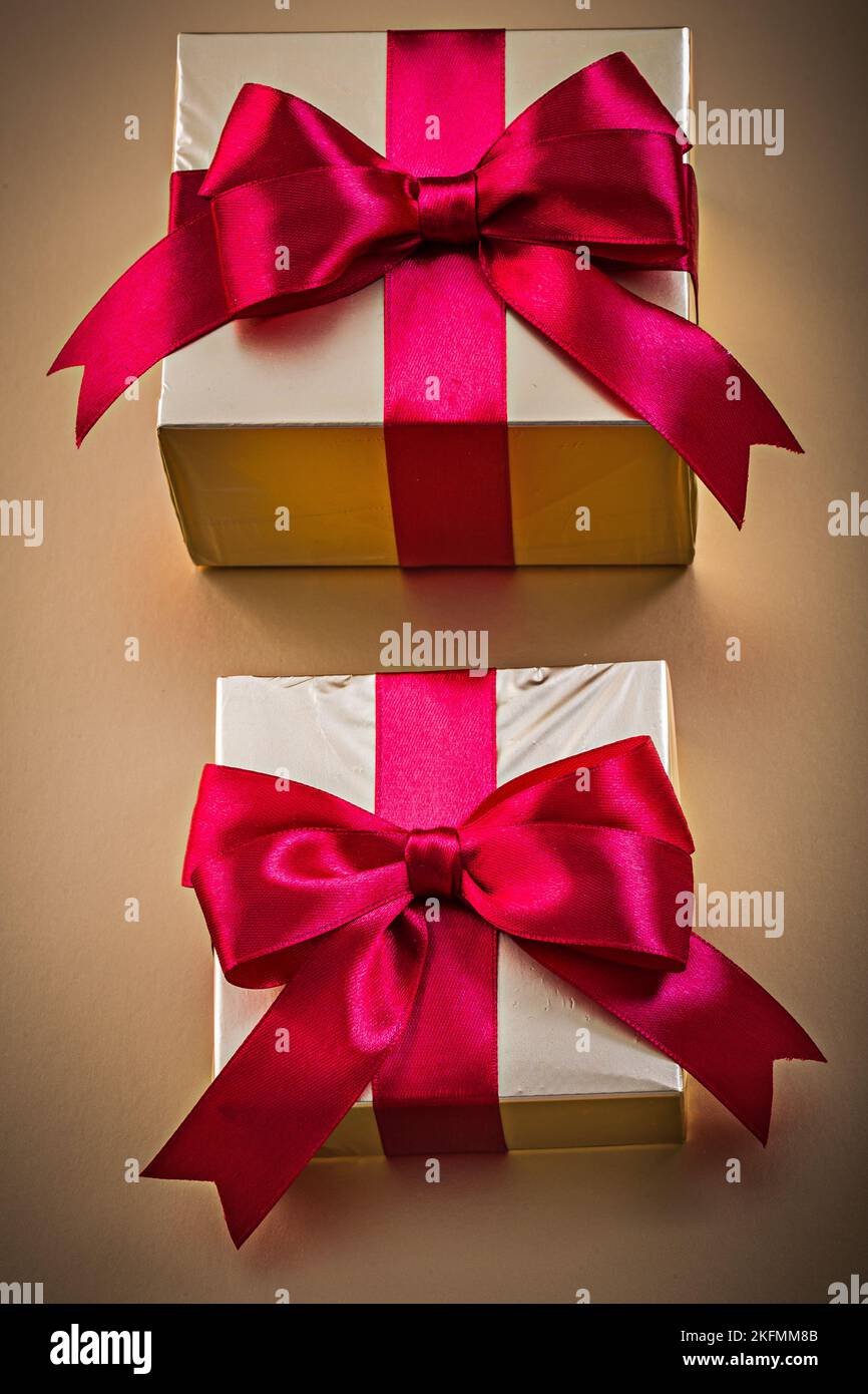 Wrapped presents with tied ribbon on golden surface holidays concept ...